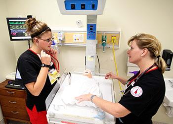 nursing students learning with infant simulator