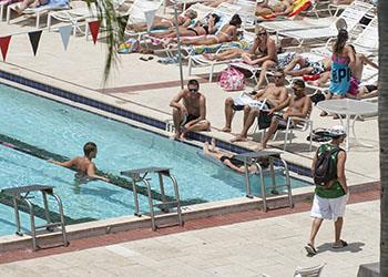 students lounging and swimming at the pool