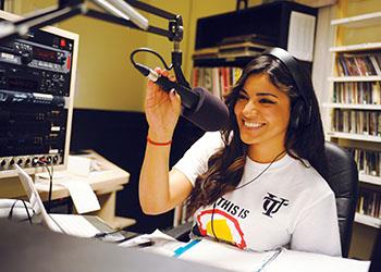 female student smiling in a radio studio