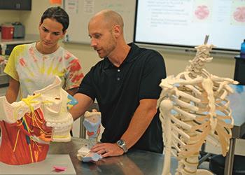 instructor teaching with skeletons in a lab