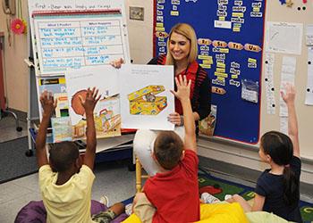 student teacher reading to elementary kids