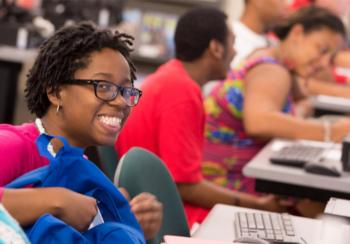 smiling student in a classroom with peers