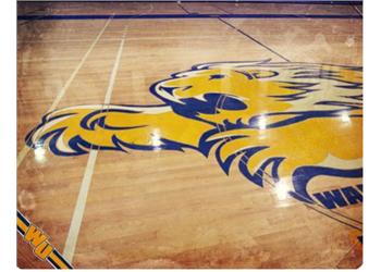 gym floor with tiger mascot and partial institution name