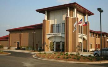 campus building with flags and clear sky