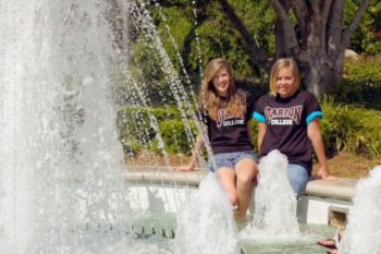 two people wearing 'darton' t-shirts by a fountain