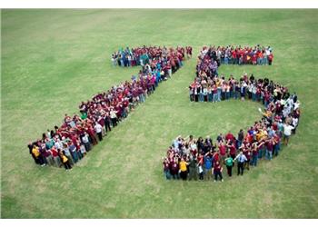 group of people forming the number '15' on grass field