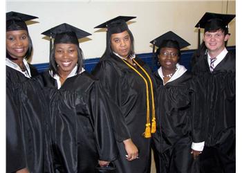 group of graduates in caps and gowns smiling