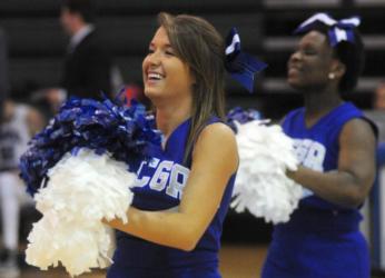 cheerleaders with white pom-poms and 'CCGO' on uniform