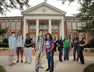 group of students standing in front of a campus building