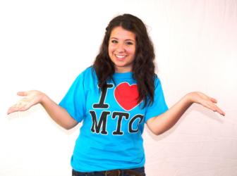 person in blue 'I ❤️ MTC' t-shirt with arms outstretched