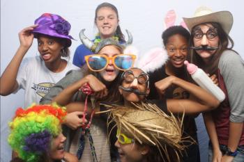 a group of people in playful hats and props posing for a photo