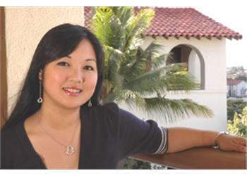 student smiling on a balcony with palm trees