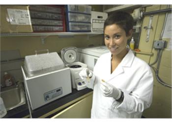 scientist in lab coat handling a pipette