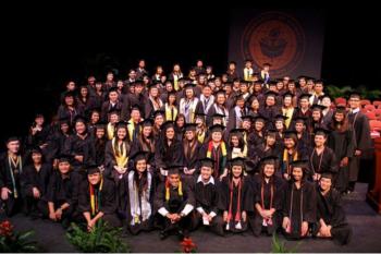 group of graduates in caps and gowns at a ceremony