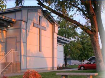 exterior of a building at dusk with cross symbol