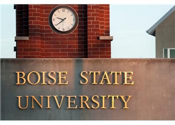 brick tower with a clock above 'boise state university' sign