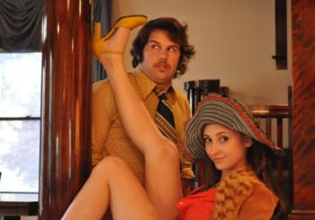 two people in vintage clothing posing playfully indoors