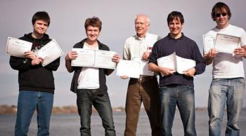 four people holding certificates beside an older man