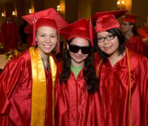 three graduates in red gowns and caps