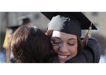 graduate hugging another person