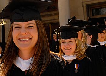 graduates smiling wearing caps and gowns