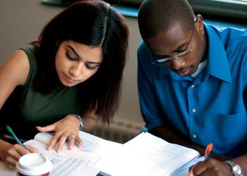 two students studying with books and coffee