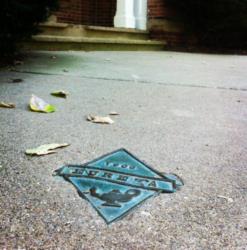 metal plaque with 'Eureka College' on ground among leaves