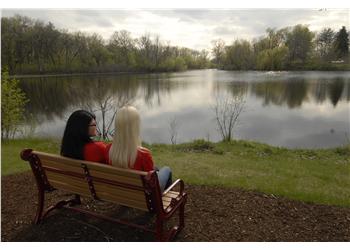 two people on bench overlooking a lake