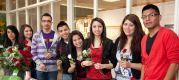 group of students holding roses indoors