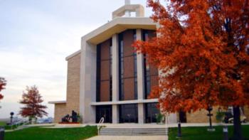 campus building with a vibrant red tree in autumn