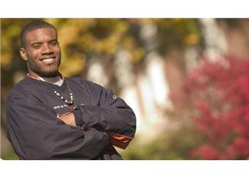 smiling man with arms crossed outdoors