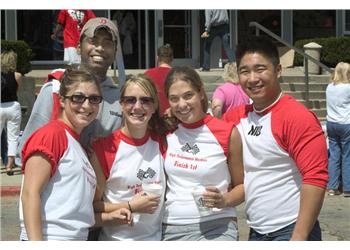 group of smiling students wearing event t-shirts