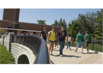 students walking across campus bridge