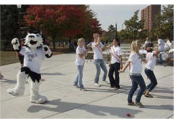 mascot dancing with students outdoors