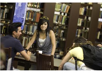 two students chatting in a library setting