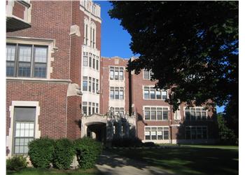 red brick university building with green trees