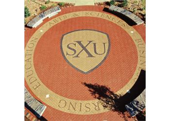 brick pavement with 'SXU' shield logo and text 'education arts & sciences business'