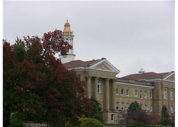 historic building with clock tower behind fall foliage