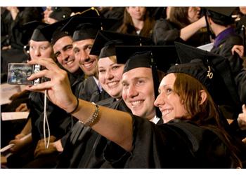 graduates taking a selfie at commencement ceremony