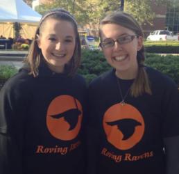 two people smiling wearing 'roving ravens' t-shirts