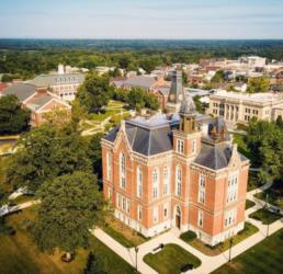 aerial view of a historic red-brick building with manicured lawns