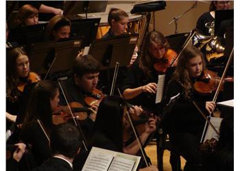 orchestra performing on stage with string instruments