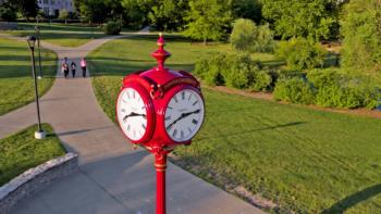a red clock tower on a university campus