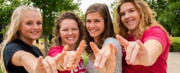 four students pointing at the camera