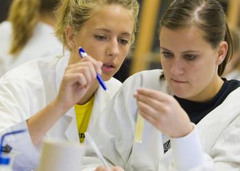 two students focused on a science lab activity