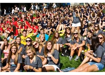 students sitting on grass at outdoor event