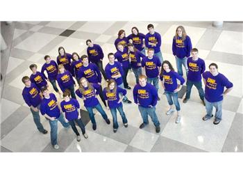 group forming 'UNI' with purple shirts