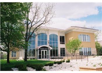 modern building with large windows and a garden