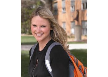 smiling student with backpack outdoors