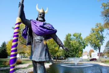 statue of a viking with striped staff by a fountain